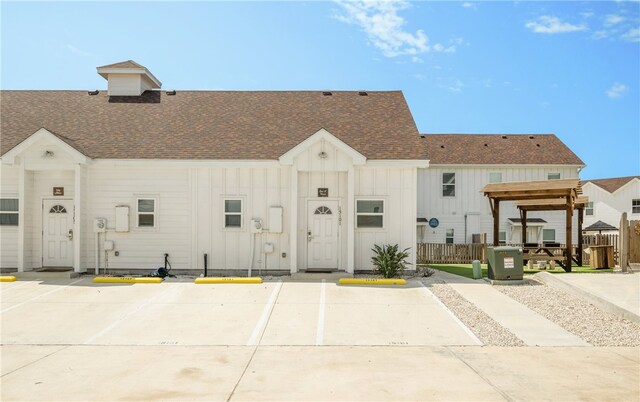 15101 Boca Grandi Dr, Corpus Christi, TX 78418 - view of property with uncovered parking, fence, board and batten siding, and roof with shingles