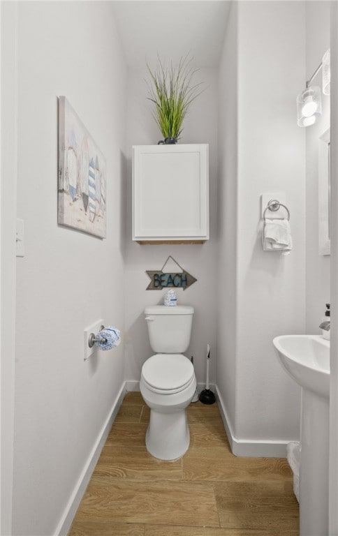 15101 Boca Grandi Dr, Corpus Christi, TX 78418 - bathroom featuring baseboards, wood finished floors, and toilet