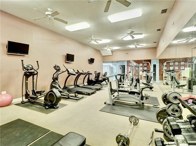 exercise room with carpet flooring and a textured ceiling