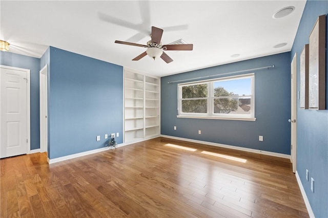 6031 Lost Creek Dr, Corpus Christi, TX 78413 - unfurnished room with built in shelves, baseboards, a ceiling fan, and wood finished floors