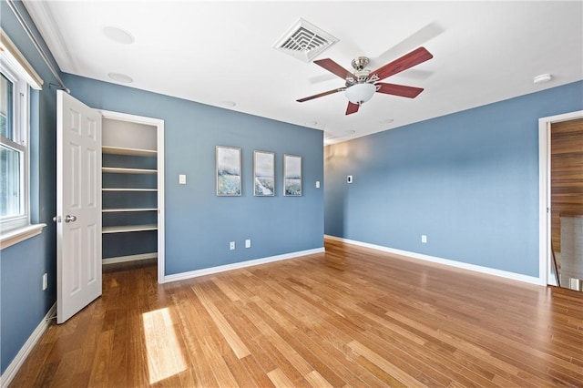 6031 Lost Creek Dr, Corpus Christi, TX 78413 - unfurnished bedroom with baseboards, visible vents, a spacious closet, a ceiling fan, and wood finished floors