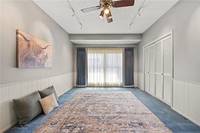 6031 Lost Creek Dr, Corpus Christi, TX 78413 - unfurnished bedroom with a textured ceiling, carpet floors, rail lighting, and a wainscoted wall