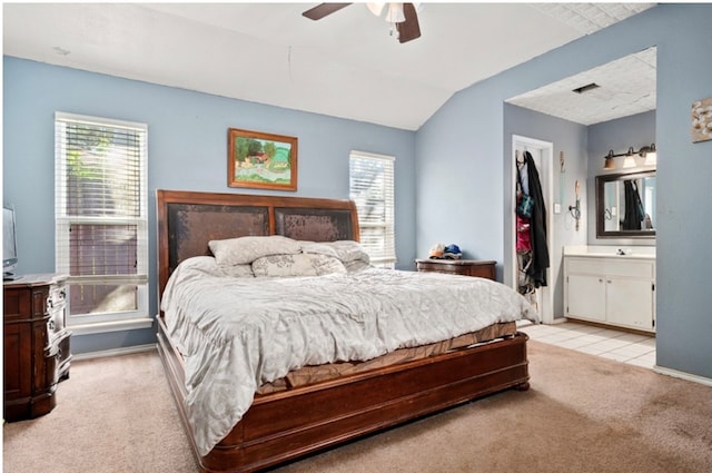 bedroom featuring light carpet, connected bathroom, ceiling fan, and lofted ceiling