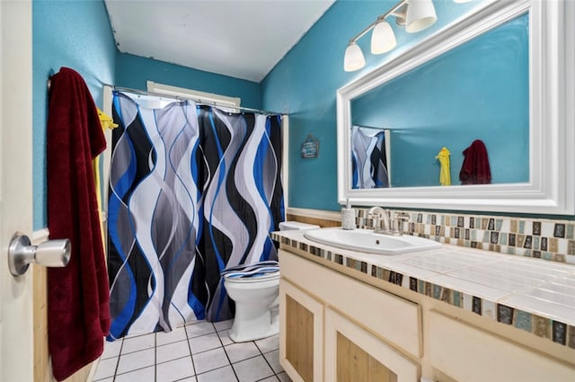 bathroom featuring tile patterned floors, decorative backsplash, toilet, and vanity