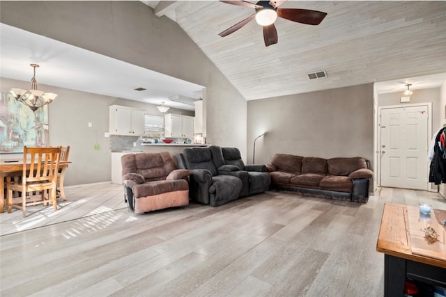 living room with ceiling fan with notable chandelier, light wood-type flooring, and high vaulted ceiling