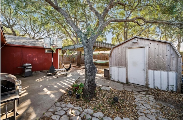 view of patio / terrace with area for grilling and a storage shed