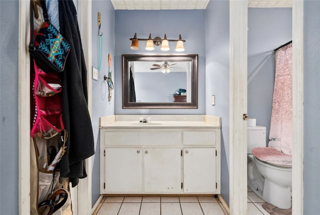 bathroom with tile patterned flooring, vanity, curtained shower, and toilet