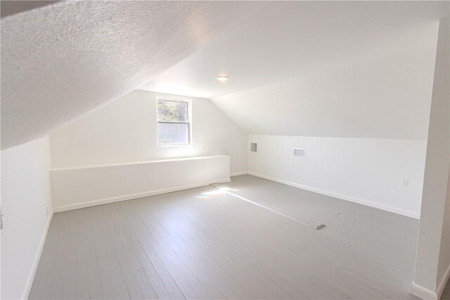 4338 Cottage St, Corpus Christi, TX 78415 - bonus room featuring baseboards, wood finished floors, lofted ceiling, and a textured ceiling