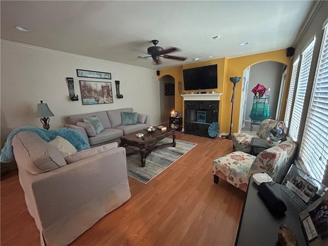 1645 W Manor Dr W, Corpus Christi, TX 78412 - living area with arched walkways, wood finished floors, ceiling fan, a glass covered fireplace, and crown molding