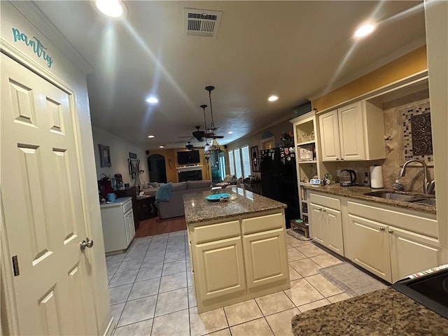 1645 W Manor Dr W, Corpus Christi, TX 78412 - kitchen with freestanding refrigerator, a kitchen island, light tile patterned floors, ornamental molding, and a ceiling fan