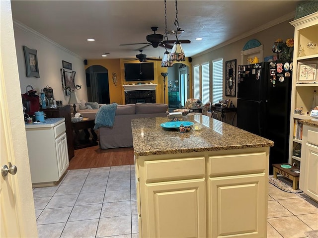1645 W Manor Dr W, Corpus Christi, TX 78412 - kitchen with freestanding refrigerator, crown molding, arched walkways, light tile patterned flooring, and ceiling fan