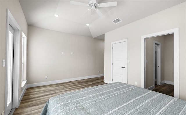 unfurnished bedroom featuring wood-type flooring, vaulted ceiling, and multiple windows