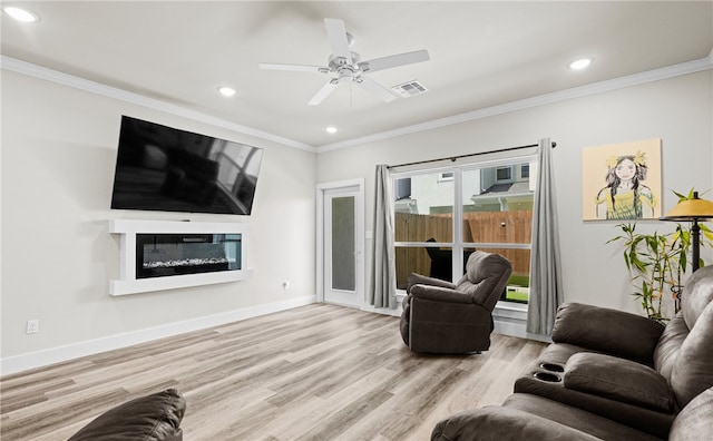 living room with crown molding, ceiling fan, and light wood-type flooring