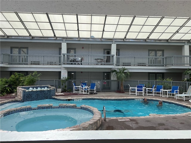 view of swimming pool featuring a patio and a hot tub