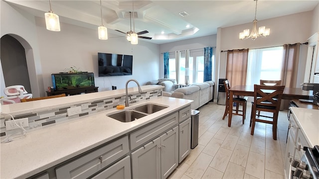 kitchen with beamed ceiling, hanging light fixtures, sink, and coffered ceiling