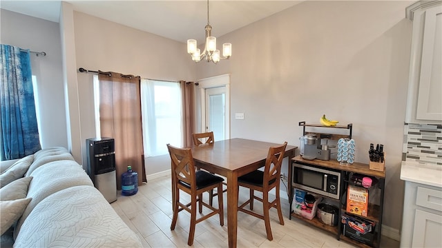 dining space with light wood-type flooring and a notable chandelier