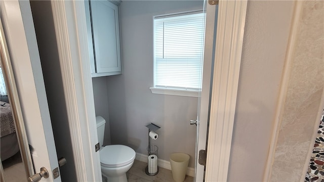 bathroom with a wealth of natural light, tile patterned flooring, and toilet