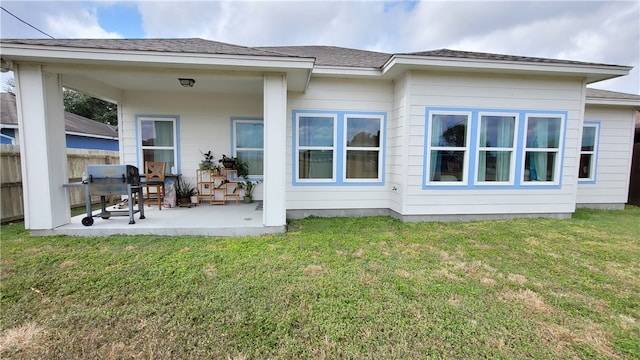 back of house featuring a patio and a yard