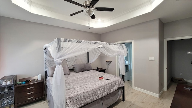 bedroom featuring light hardwood / wood-style floors, crown molding, ceiling fan, and a raised ceiling