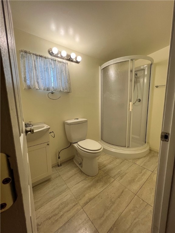 bathroom with vanity, toilet, and a shower with shower door