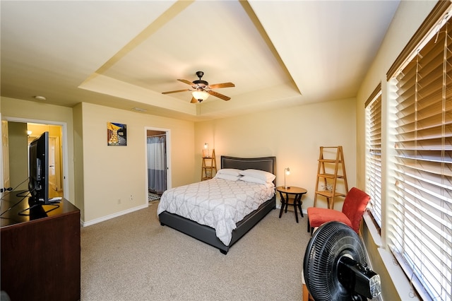 bedroom with carpet floors, ceiling fan, and a raised ceiling