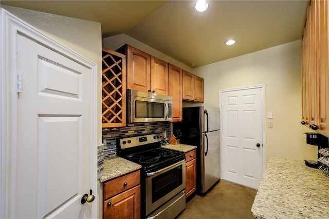 kitchen with lofted ceiling, appliances with stainless steel finishes, and tasteful backsplash