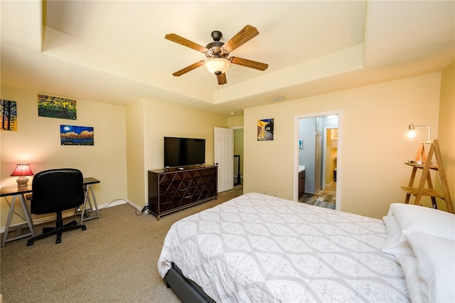 carpeted bedroom featuring ensuite bathroom, ceiling fan, and a raised ceiling