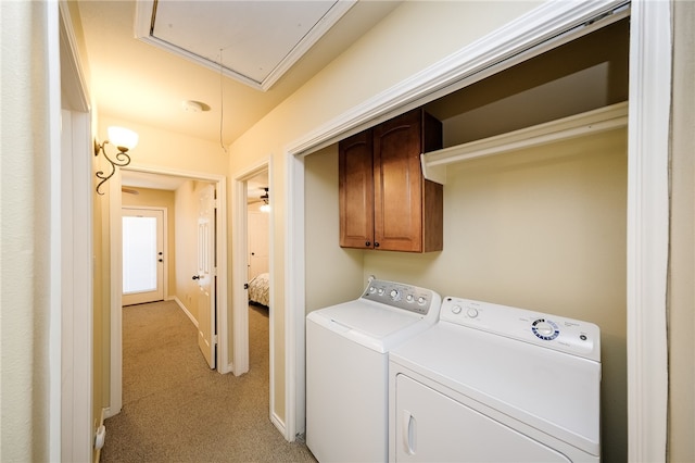 laundry room with cabinets, light colored carpet, and washer and clothes dryer