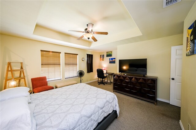 bedroom featuring carpet floors, ceiling fan, and a tray ceiling