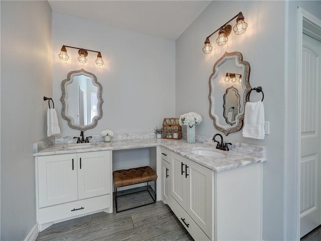 full bath with double vanity, a sink, and wood finished floors