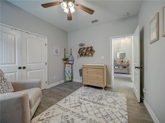 sitting room with visible vents, ceiling fan, baseboards, and wood finished floors