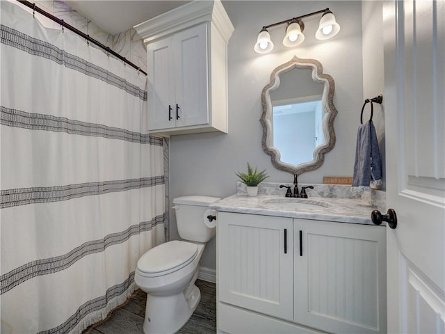 full bath with curtained shower, vanity, and toilet