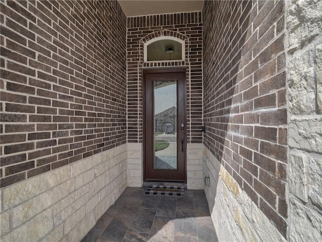 view of exterior entry with brick siding