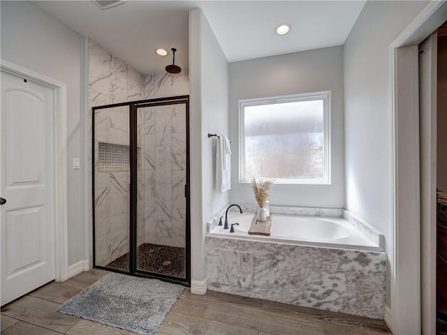 full bathroom featuring wood tiled floor, a garden tub, a marble finish shower, and recessed lighting