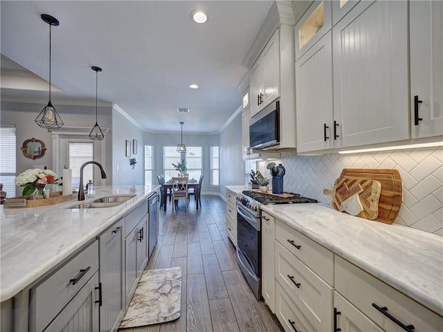 kitchen featuring decorative backsplash, appliances with stainless steel finishes, dark wood-type flooring, crown molding, and a sink