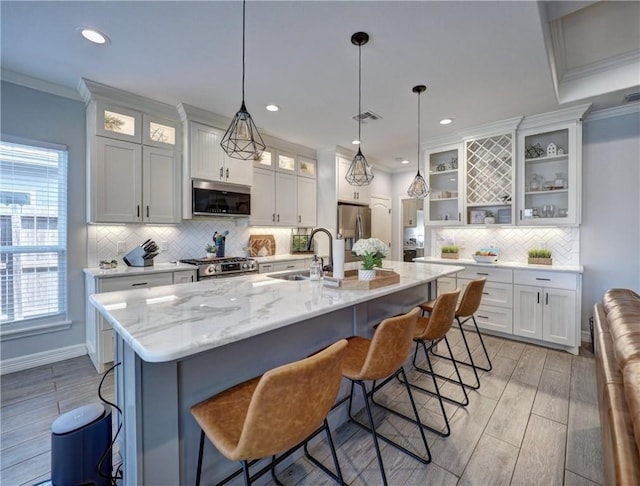 kitchen featuring visible vents, white cabinets, stainless steel appliances, crown molding, and wood finish floors