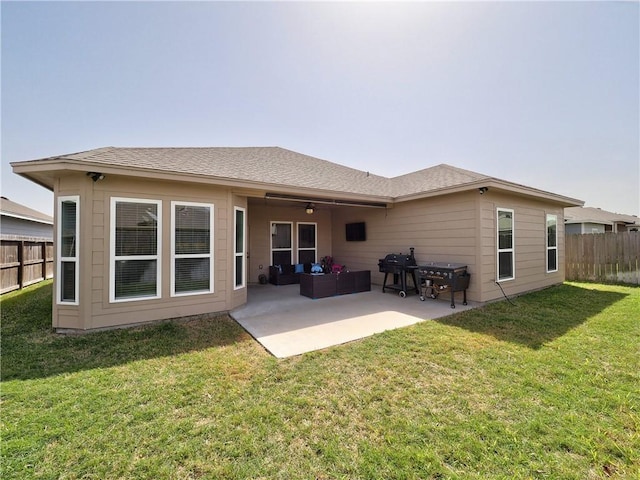 rear view of house with roof with shingles, a patio, a lawn, ceiling fan, and fence