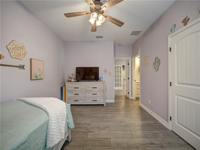 bedroom with wood tiled floor, visible vents, ceiling fan, and baseboards