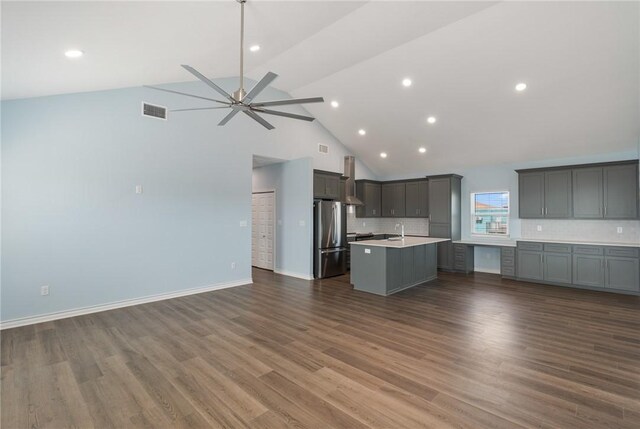 kitchen with open floor plan, a sink, visible vents, and freestanding refrigerator