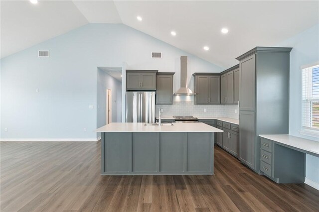 kitchen with a sink, gray cabinets, visible vents, wall chimney range hood, and appliances with stainless steel finishes