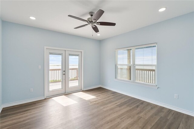 spare room featuring baseboards, french doors, wood finished floors, and ceiling fan
