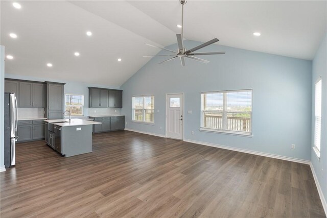 kitchen with gray cabinets, open floor plan, stainless steel appliances, and a sink