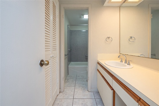 bathroom featuring vanity, tile patterned flooring, a textured ceiling, and tiled shower / bath