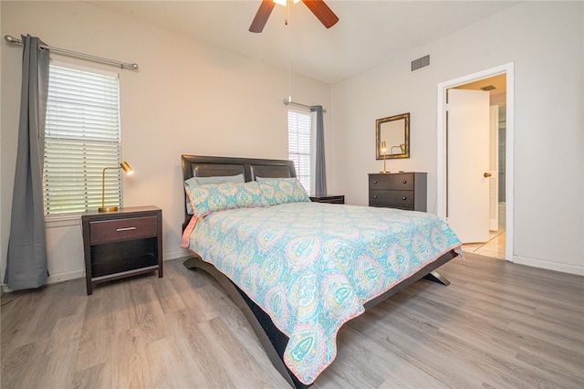 bedroom with hardwood / wood-style flooring, ensuite bath, and ceiling fan