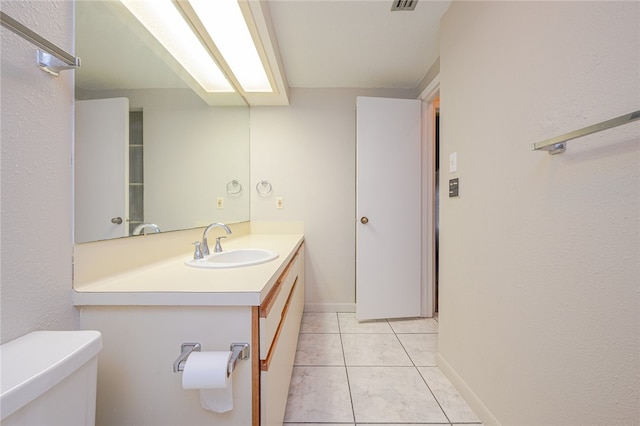 bathroom featuring vanity, tile patterned floors, and toilet