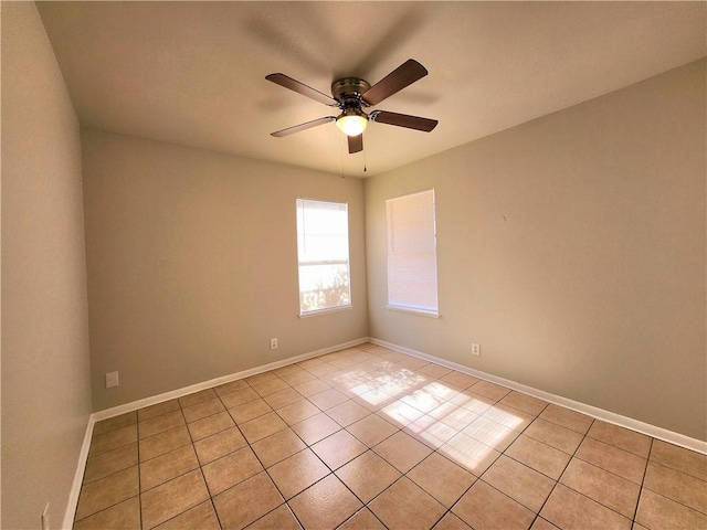 spare room with ceiling fan and light tile patterned flooring