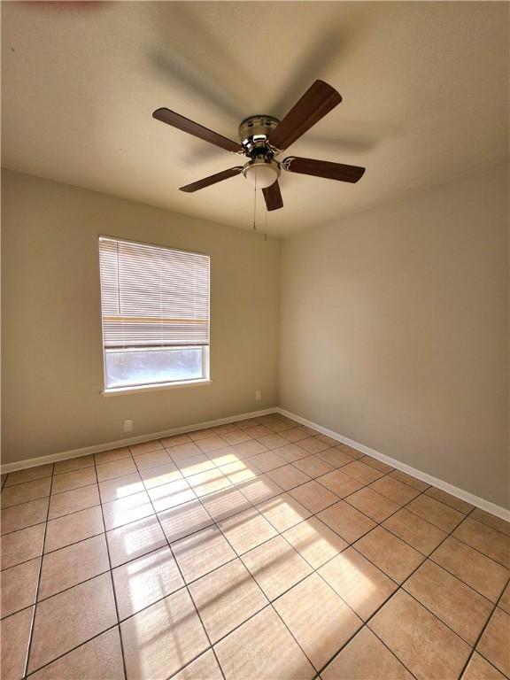 unfurnished room with ceiling fan and light tile patterned floors