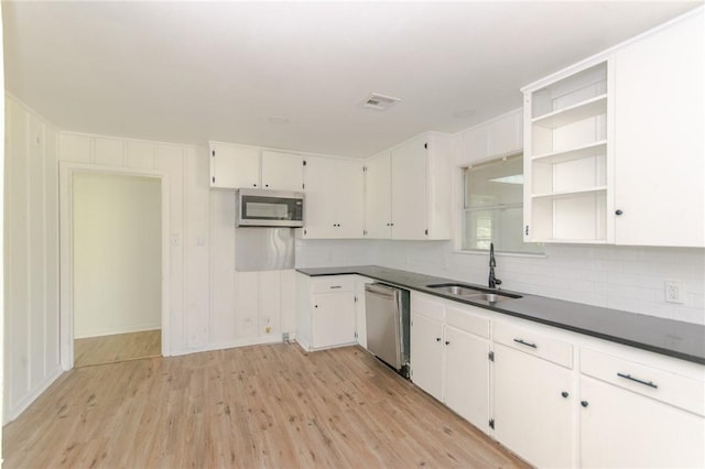 704 E Henderson St, Bishop, TX 78343 - kitchen featuring stainless steel appliances, light wood finished floors, dark countertops, and white cabinets