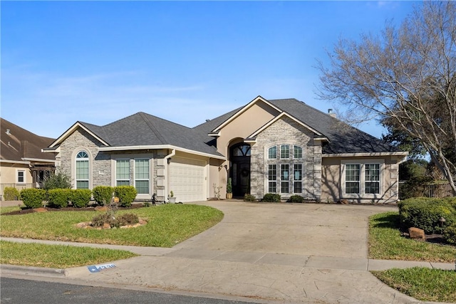 view of front of home with a garage, stone siding, a front yard, and driveway