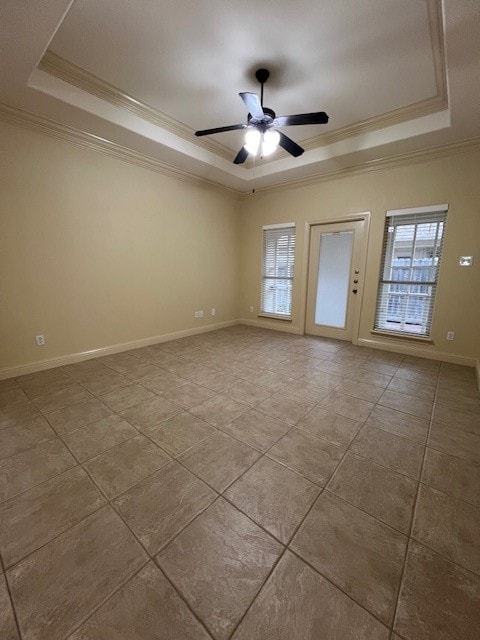 unfurnished room with ornamental molding, a wealth of natural light, and a tray ceiling